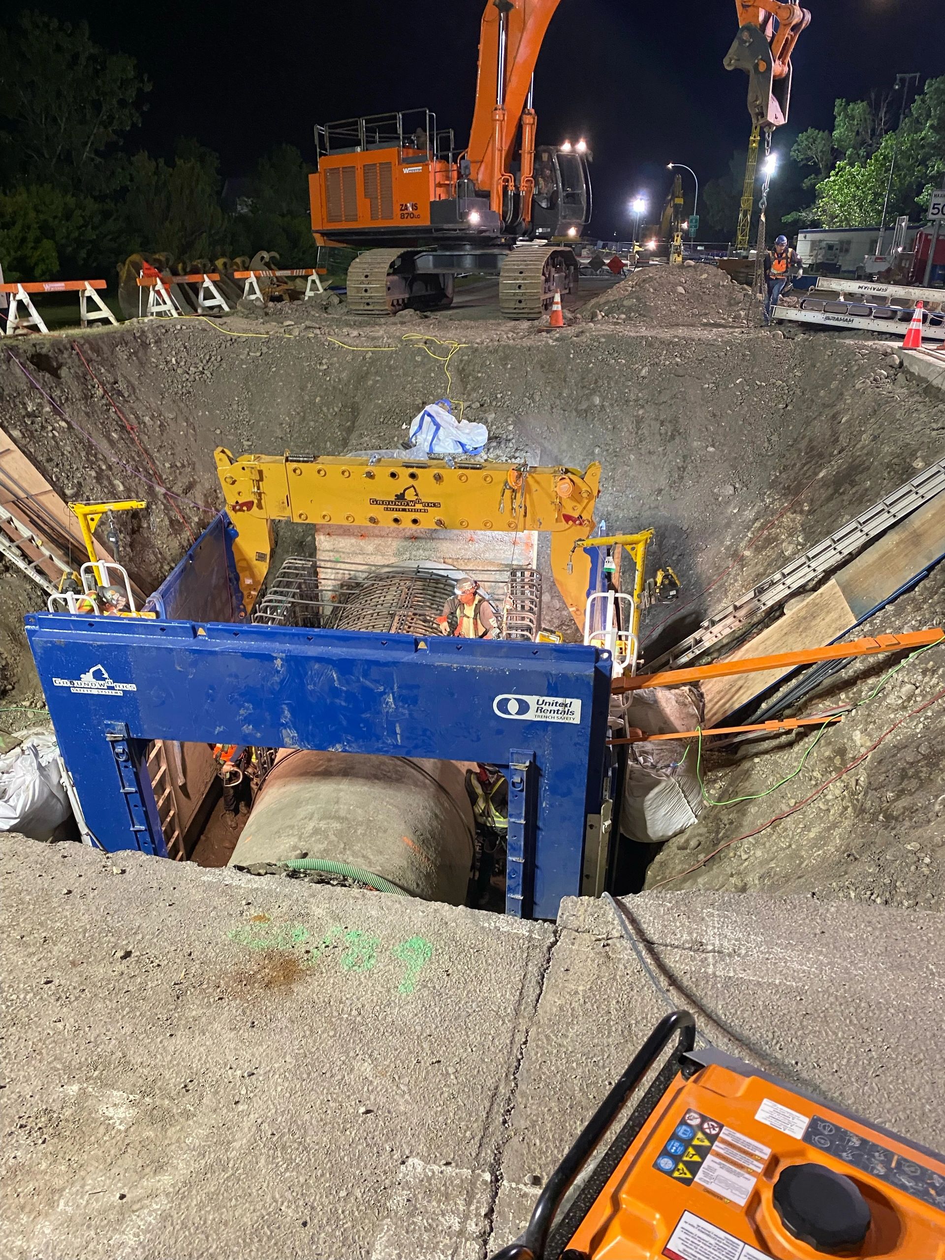 Rebar installation inside an excavation with construction equipment
